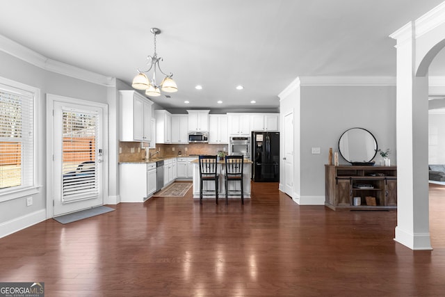 kitchen with stainless steel appliances, a center island, white cabinets, and a kitchen breakfast bar