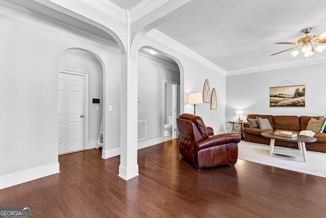 living room featuring baseboards, visible vents, a ceiling fan, arched walkways, and dark wood finished floors