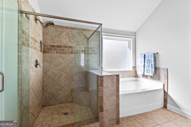 bathroom featuring a garden tub, vaulted ceiling, a shower stall, and tile patterned floors