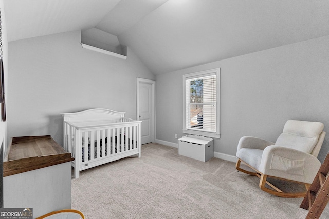 bedroom featuring lofted ceiling, light carpet, a crib, and baseboards