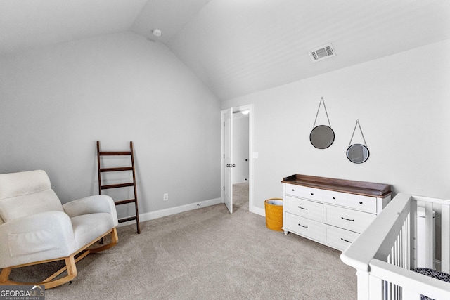 bedroom with light colored carpet, visible vents, vaulted ceiling, a crib, and baseboards