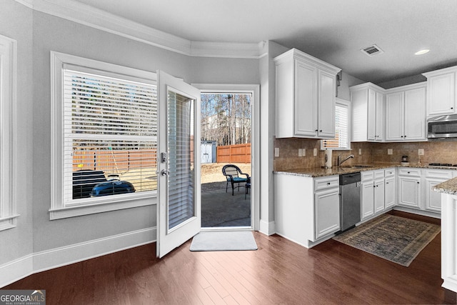 kitchen featuring stone counters, dark wood finished floors, stainless steel appliances, decorative backsplash, and white cabinets