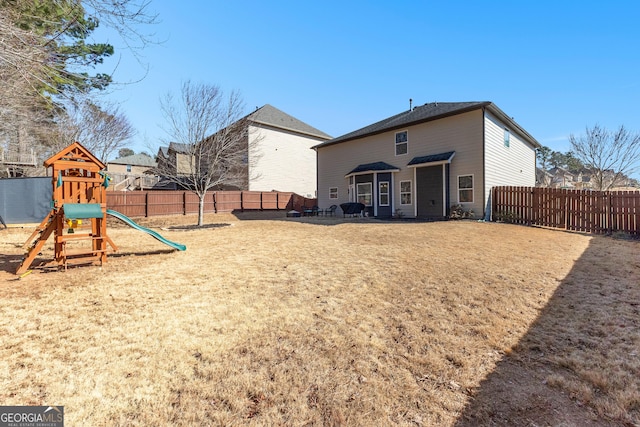 exterior space with a playground and a fenced backyard