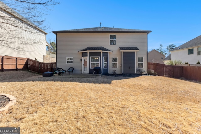 rear view of house featuring a patio area, a fenced backyard, and a lawn