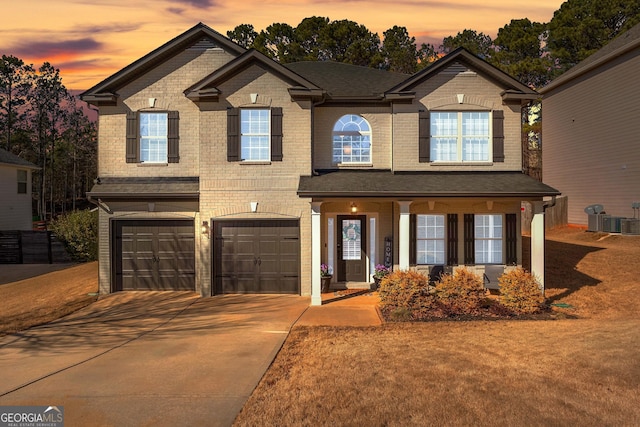 view of front of property featuring driveway, brick siding, an attached garage, and central air condition unit