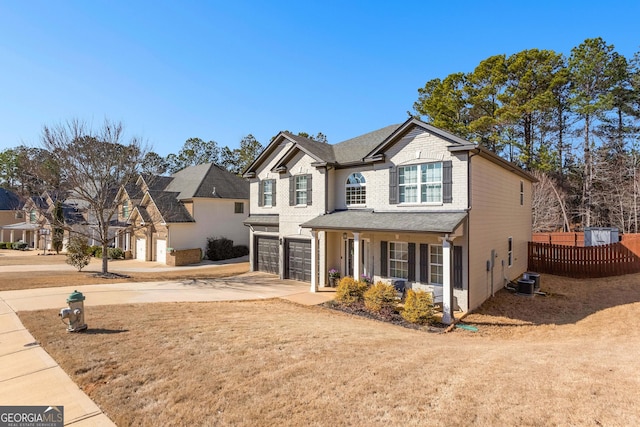 traditional-style home with a garage, concrete driveway, covered porch, fence, and cooling unit