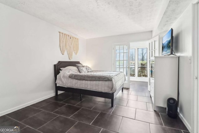 bedroom featuring dark tile patterned flooring and a textured ceiling