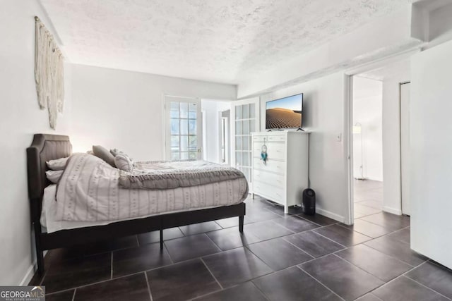 bedroom with dark tile patterned flooring and a textured ceiling