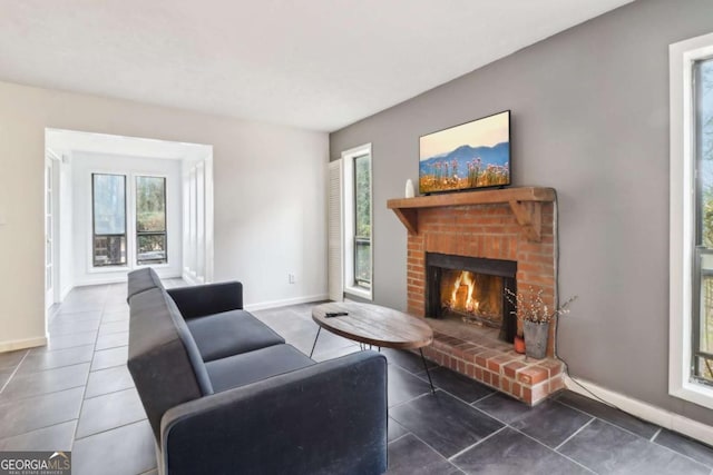 tiled living room featuring a brick fireplace