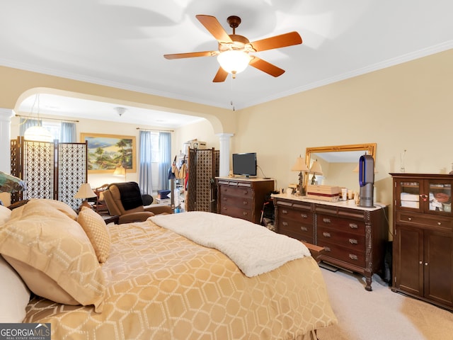 carpeted bedroom featuring ornate columns, ornamental molding, and ceiling fan