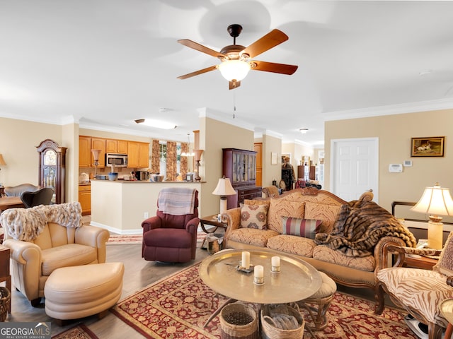 living room with ornamental molding, light hardwood / wood-style floors, and ceiling fan