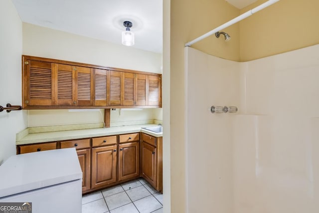 kitchen with pendant lighting, light tile patterned floors, and sink