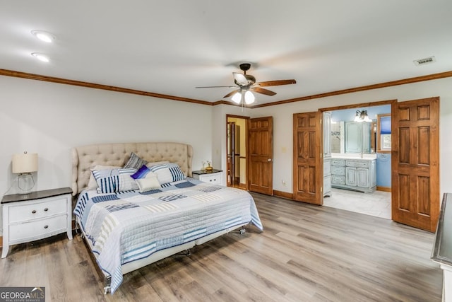 bedroom with crown molding, light hardwood / wood-style flooring, ensuite bath, and ceiling fan