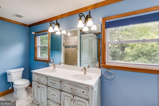 bathroom with toilet, a chandelier, a tile shower, ornamental molding, and vanity