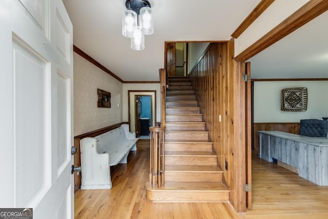 staircase with crown molding and wood-type flooring