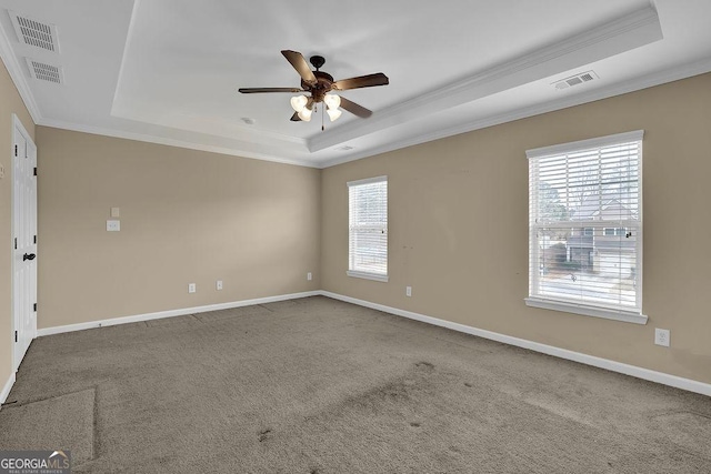 carpeted empty room with crown molding, ceiling fan, and a raised ceiling