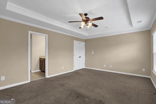 empty room featuring crown molding, light colored carpet, a raised ceiling, and ceiling fan