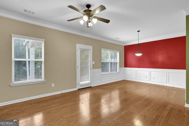 empty room featuring hardwood / wood-style flooring, ceiling fan, and crown molding