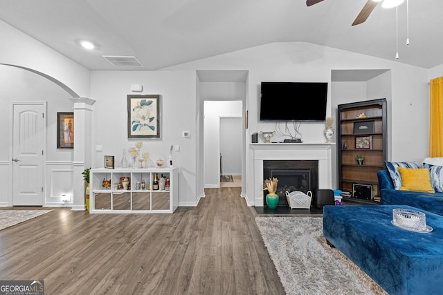 living room with lofted ceiling, wood-type flooring, ceiling fan, and ornate columns