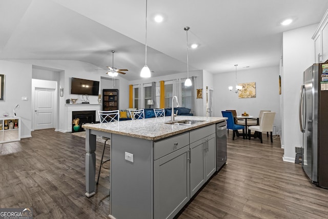 kitchen with sink, a breakfast bar area, gray cabinetry, a center island with sink, and stainless steel appliances