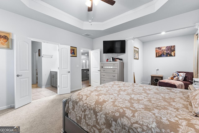 carpeted bedroom with ornamental molding, connected bathroom, and a raised ceiling