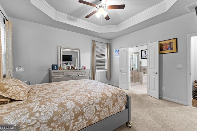 bedroom with ensuite bathroom, light colored carpet, ornamental molding, a raised ceiling, and ceiling fan