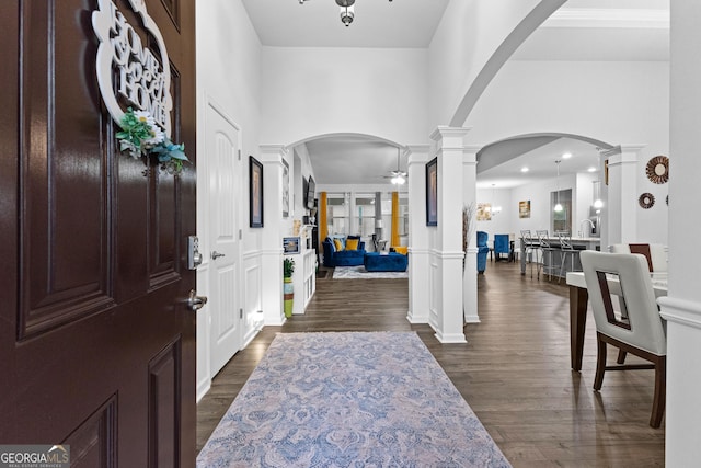 entrance foyer with ceiling fan, dark hardwood / wood-style flooring, decorative columns, and a high ceiling