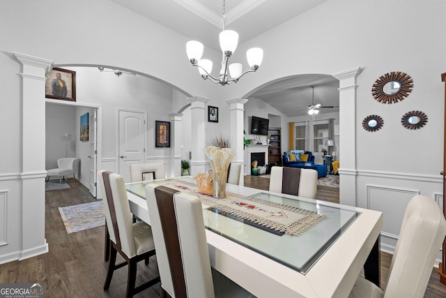 dining area featuring ornate columns, ceiling fan with notable chandelier, lofted ceiling, dark hardwood / wood-style flooring, and a raised ceiling