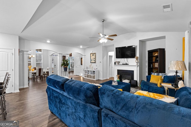 living room with decorative columns, ceiling fan, lofted ceiling, and dark hardwood / wood-style flooring