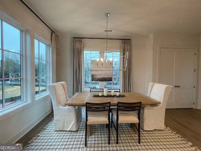 dining space with wood-type flooring and a notable chandelier