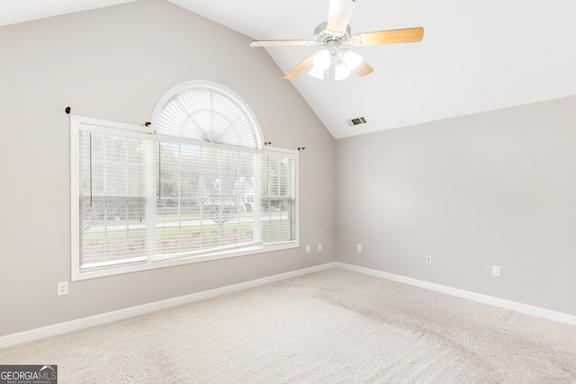 carpeted empty room with ceiling fan and high vaulted ceiling