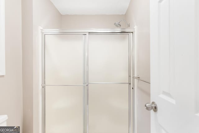 bathroom with a shower with door