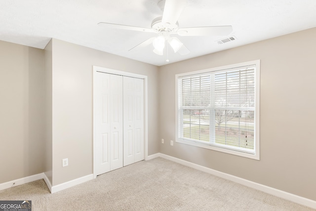 unfurnished bedroom featuring carpet floors, a closet, and ceiling fan