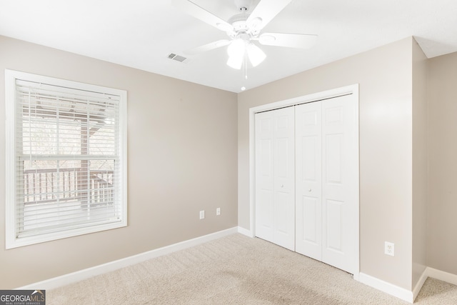 unfurnished bedroom with carpet flooring, ceiling fan, and a closet