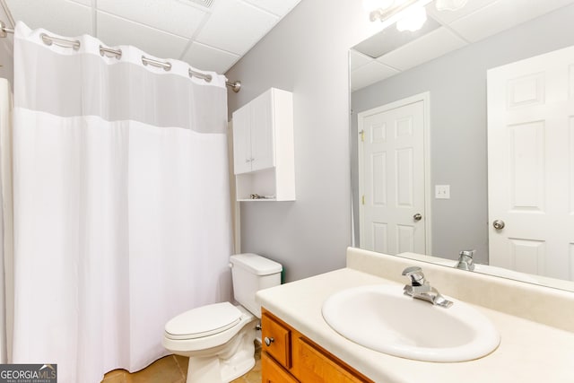 bathroom featuring vanity, a drop ceiling, and toilet