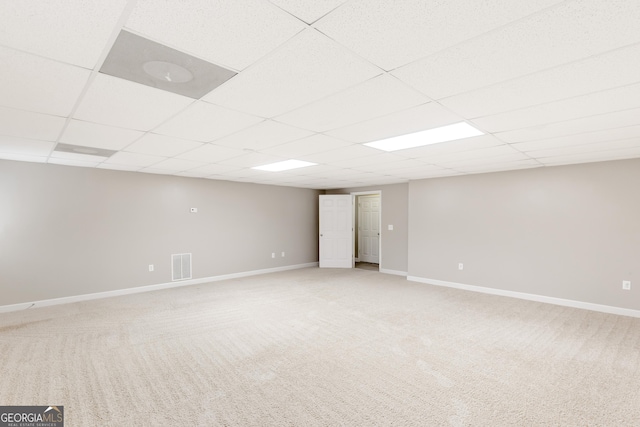 basement with carpet and a paneled ceiling