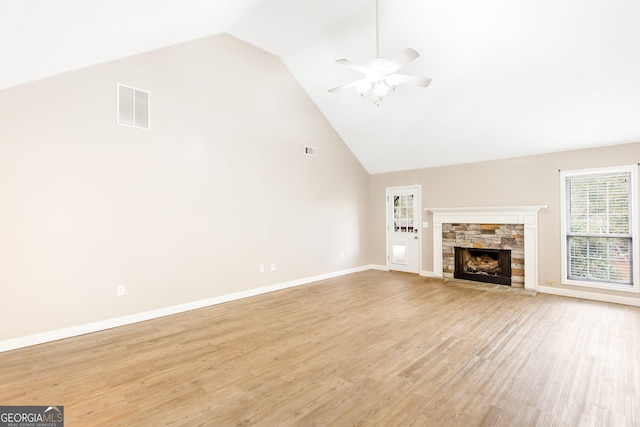 unfurnished living room featuring a fireplace, high vaulted ceiling, ceiling fan, and light wood-type flooring