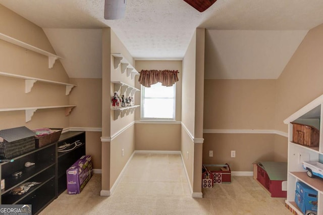 walk in closet featuring lofted ceiling and light colored carpet