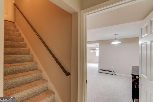 stairway with a baseboard radiator and carpet floors