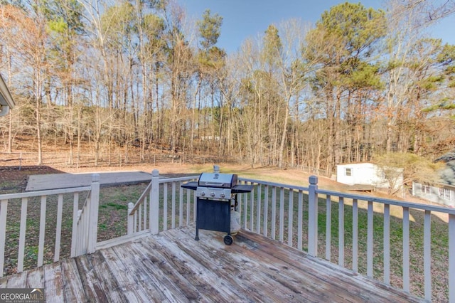 wooden deck with a storage shed and a lawn