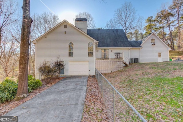 rear view of house featuring a garage and a deck