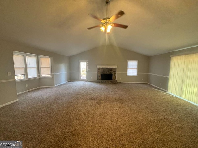 unfurnished living room featuring lofted ceiling, a fireplace, and a wealth of natural light