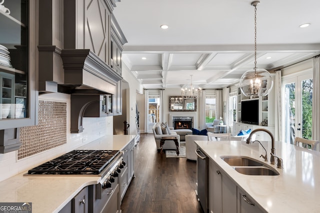 kitchen featuring sink, decorative light fixtures, gray cabinets, and light stone countertops