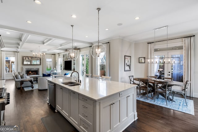 kitchen featuring white cabinetry, a kitchen island with sink, sink, and a notable chandelier