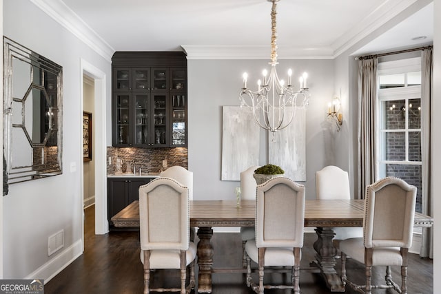 dining area featuring ornamental molding, dark hardwood / wood-style flooring, sink, and a chandelier