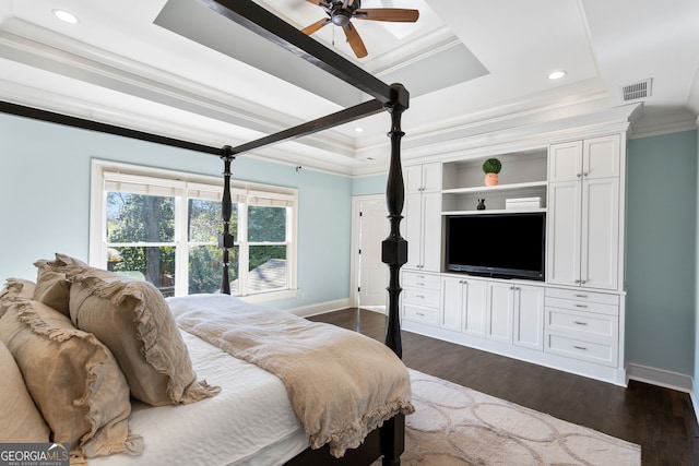 bedroom with ornamental molding, dark hardwood / wood-style flooring, and a tray ceiling