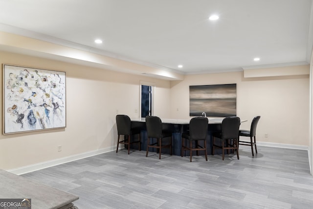 dining room with ornamental molding and bar area