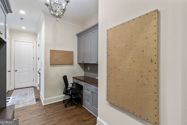 office space with dark hardwood / wood-style flooring, a notable chandelier, crown molding, and built in desk