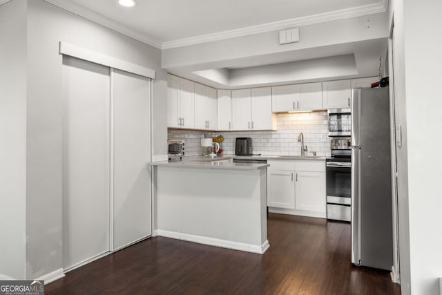 kitchen featuring sink, crown molding, stainless steel appliances, decorative backsplash, and white cabinets