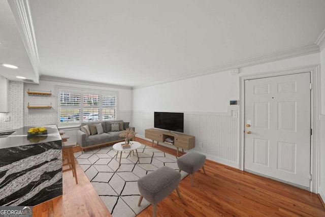 living room with hardwood / wood-style floors and crown molding